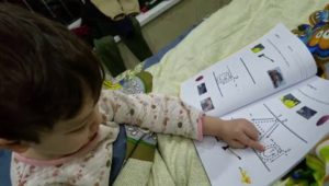 Boy tracing the letters and learning the alphabet with the Alphastrokes workbook.